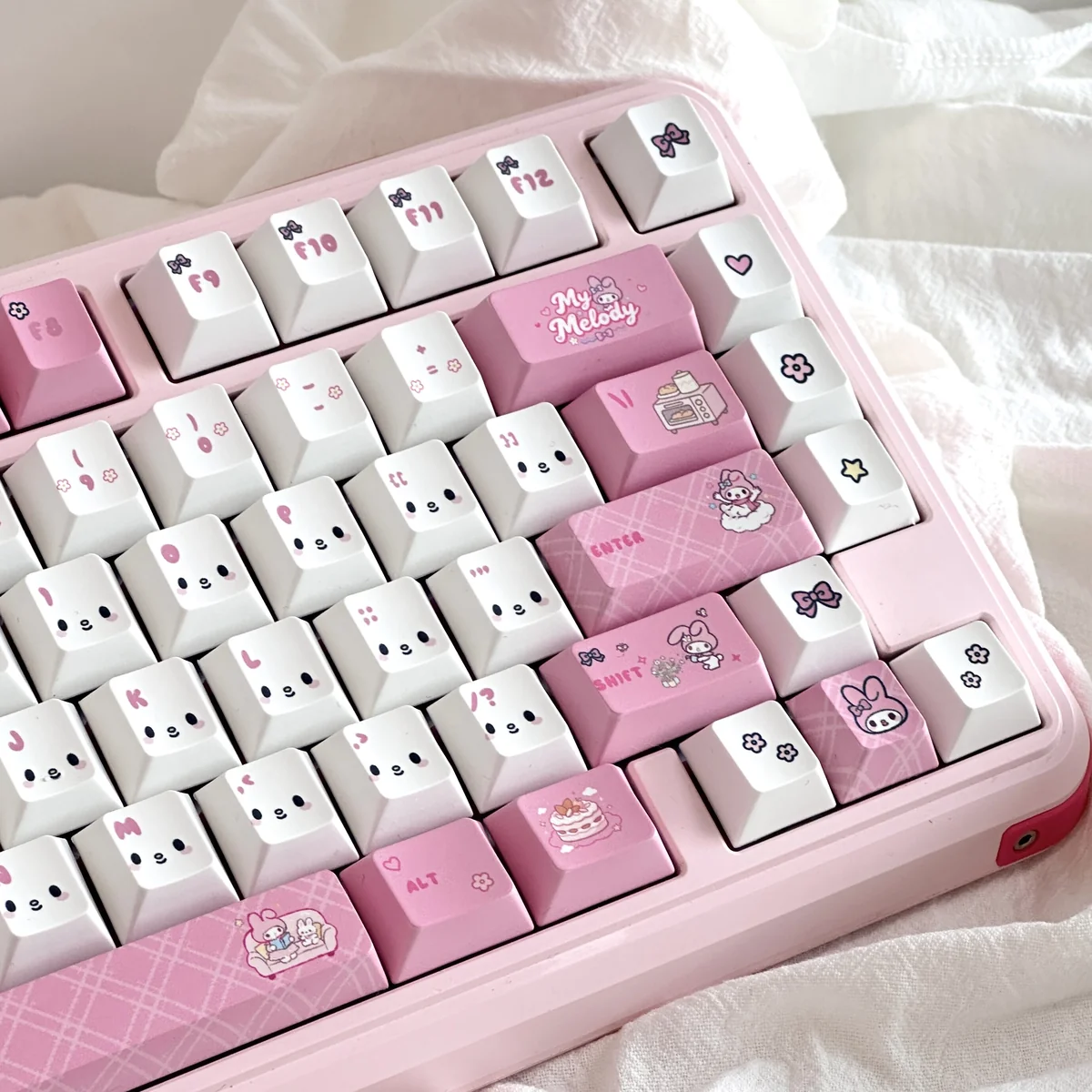Adorable My Melody PBT Dye-Sub keycaps in soft pastel pink, showcasing the iconic character art from multiple angles, adding playful charm to any keyboard.