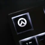 Multiple views of the translucent Overwatch R4 gaming keycap, highlighting its vibrant glow and iconic design from various angles.