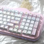 Pastel dessert keycaps in Cherry profile PBT decorate this pink keyboard with cute hand-drawn cakes, fruit, and character novelties.