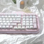 Close-up of pastel dessert keycaps in Cherry profile on a pink keyboard, showing dye-sublimated PBT set with cute dessert and character designs.