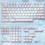 Pastel dessert keycaps in a Cherry profile PBT set, shown laid out with soft pink-blue tones, cute dessert characters, and dye-sublimated legends.