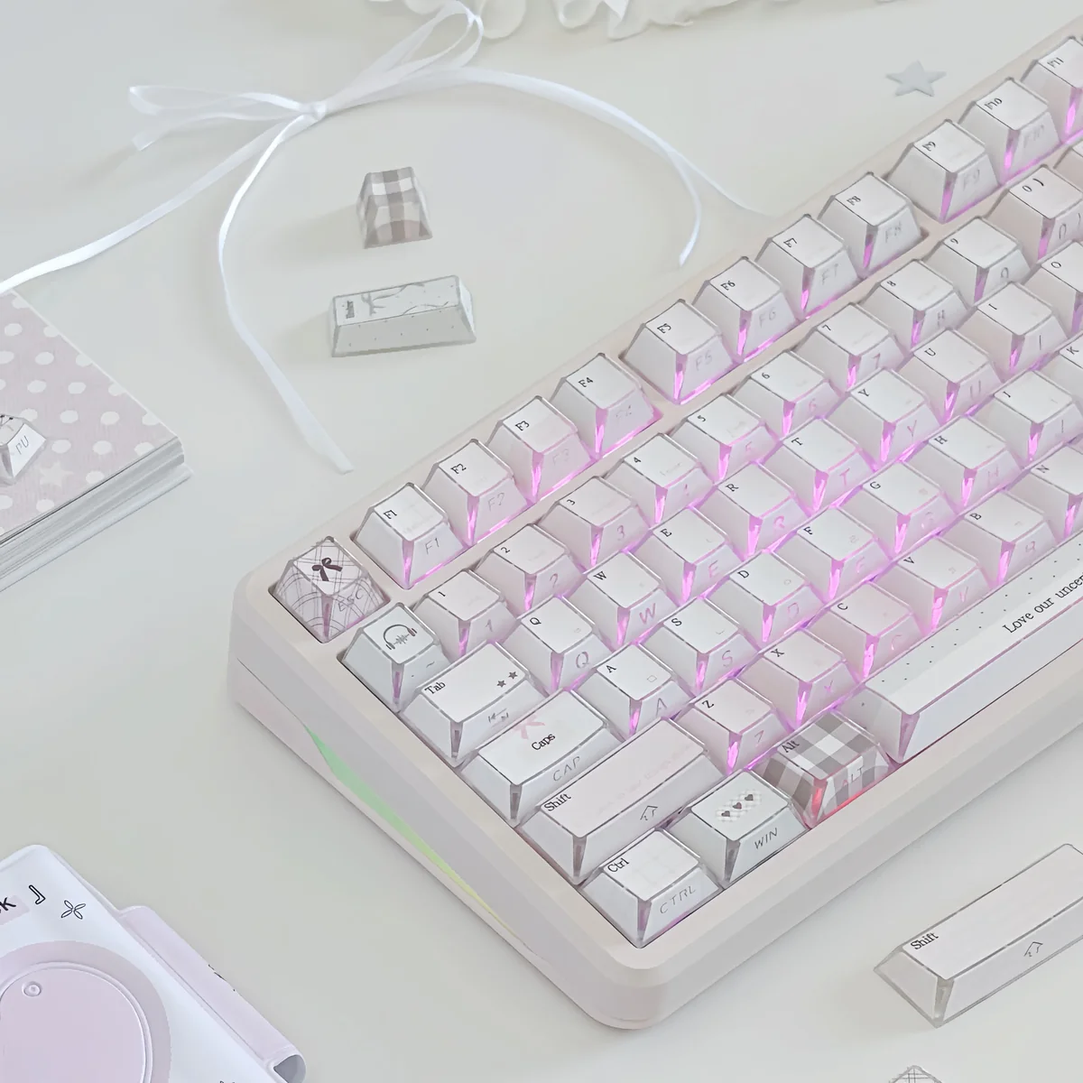 Pastel pink keycaps with side-lit PBT legends, gingham and heart details, styled with a sweet bow for a dreamy romantic desk.