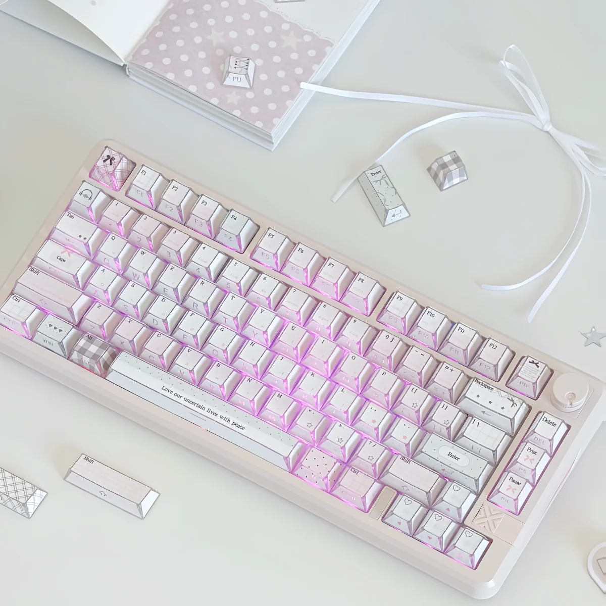 Pastel pink keycaps with gingham, bows, and heart details glow on a side-lit PBT full keycap set styled with ribbon and notebook.