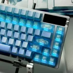 Close-up of translucent blue keycaps with pearlescent glow, frosted ice-blue shine-through finish, and delicate floral vine engravings.