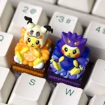 This pair of ultra-detailed 3D Pokemon artisan keycaps features dessert Cosplay Pikachu in Gengar and Mimikyu hoods on playful cake bases.