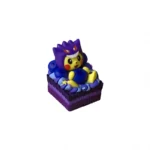 Ultra-detailed 3D angled view of a dessert-themed Cosplay Pikachu Pokemon artisan keycap in a purple Gengar hood on a layered cake base with blue frosting.