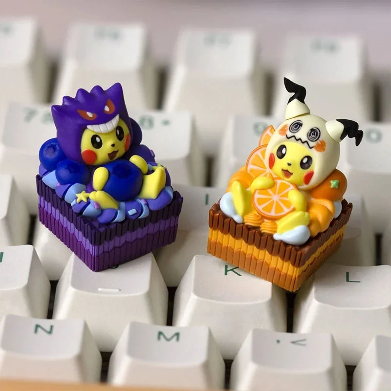 Playful ultra-detailed 3D Pokemon artisan keycaps showing dessert-themed Cosplay Pikachu wearing Gengar and Mimikyu hoods on cake bases.