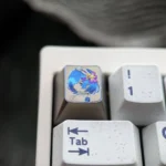Close-up of a vibrant hand-carved Re:Zero Rem titanium artisan keycap, revealing intricate colorful lines and artistic detail on its premium surface.