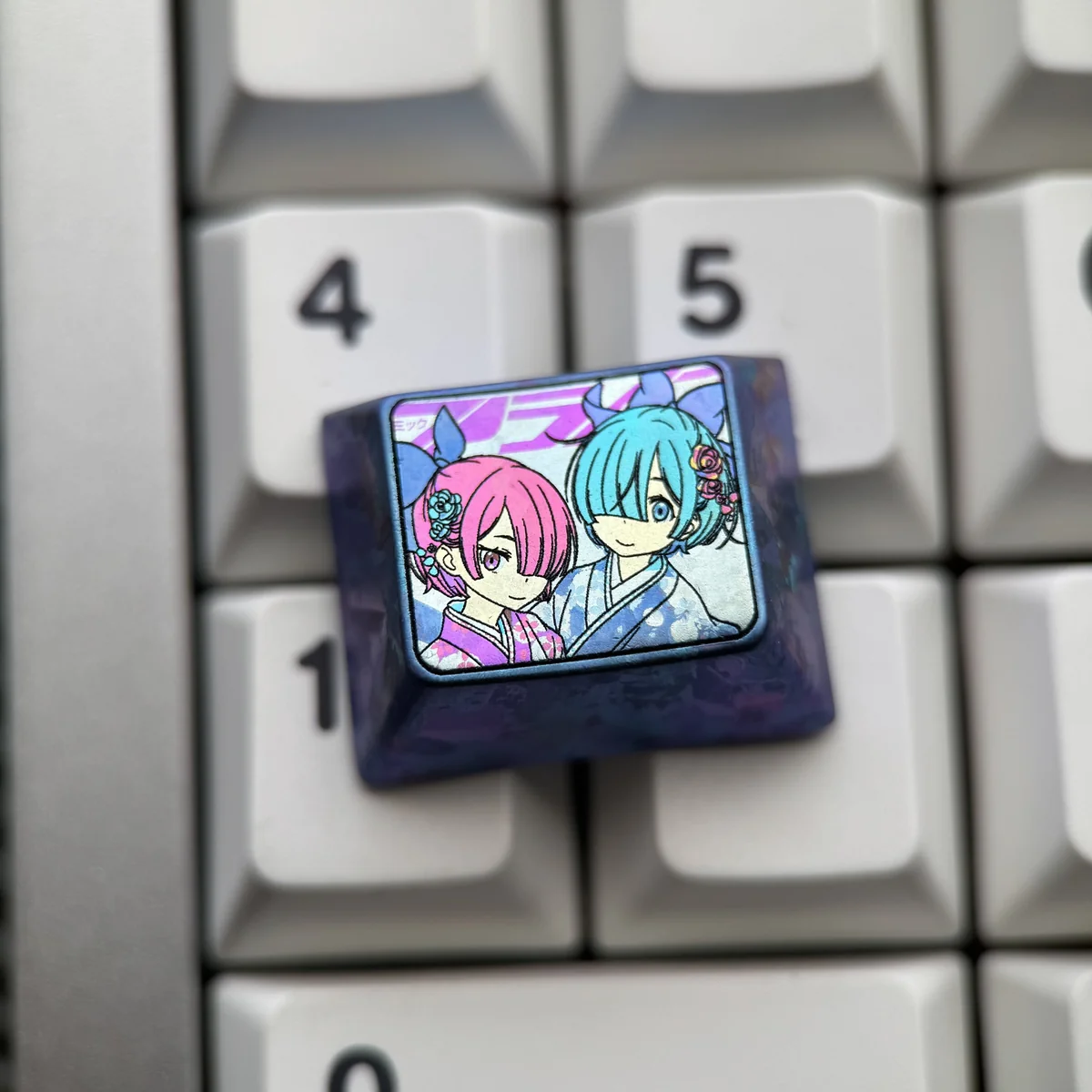 Rem Ram titanium keycap in deep blue-purple anodized titanium, featuring pastel pink and teal twin-maid anime artwork on a keyboard.