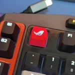Premium ROG R4 ESC gaming keycap, intricately designed with a vibrant backlit logo, showcasing its translucent material and bold aesthetic from multiple angle.