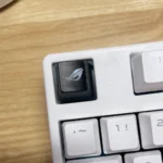 Premium ROG Logo Backlit Gaming Keycap, R4 ESC, vividly illuminated from various angles, highlighting its iconic design and vibrant translucent glow.