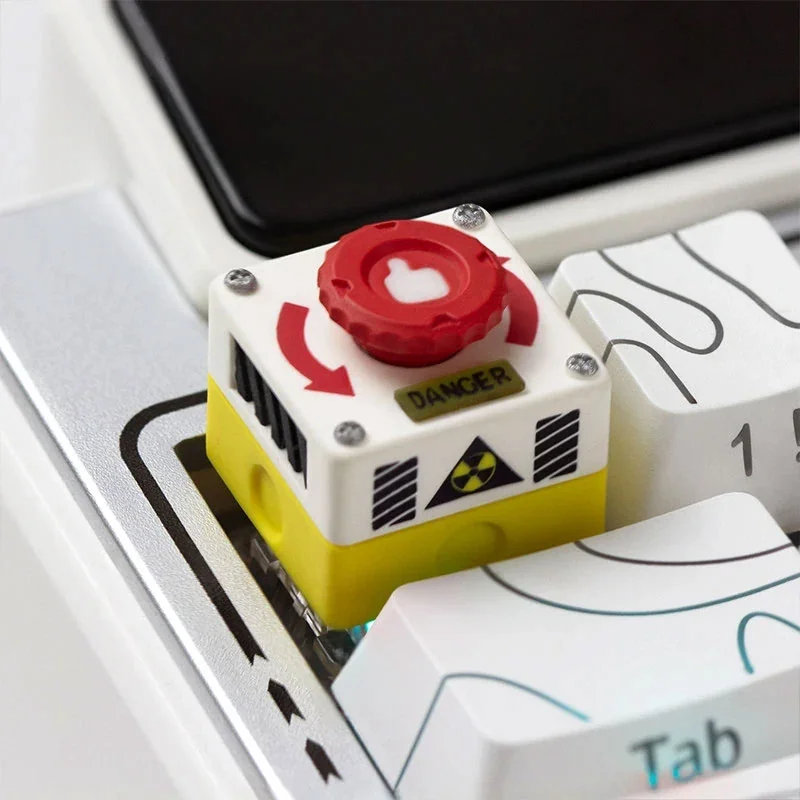 Close-up of an interactive rotatable emergency keycap, showcasing its vibrant red industrial switch design on a mechanical keyboard.