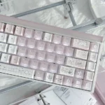 A dreamy collection of Sleepwalking pink and white PBT Cherry profile keycaps from various angles, showcasing their soft pastel glow for a playful keyboard.