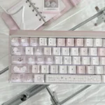 Sleepwalking pink and white PBT Cherry keycap set for keyboards, playfully showcased from multiple angles, highlighting its dreamy pastel glow and whimsical aesthetic for playful typing experience.