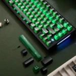 Source Code Keycaps Matrix Green translucent PC set, shown from artistic angles. The glowing green keycaps evoke a cyberpunk digital matrix aesthetic.