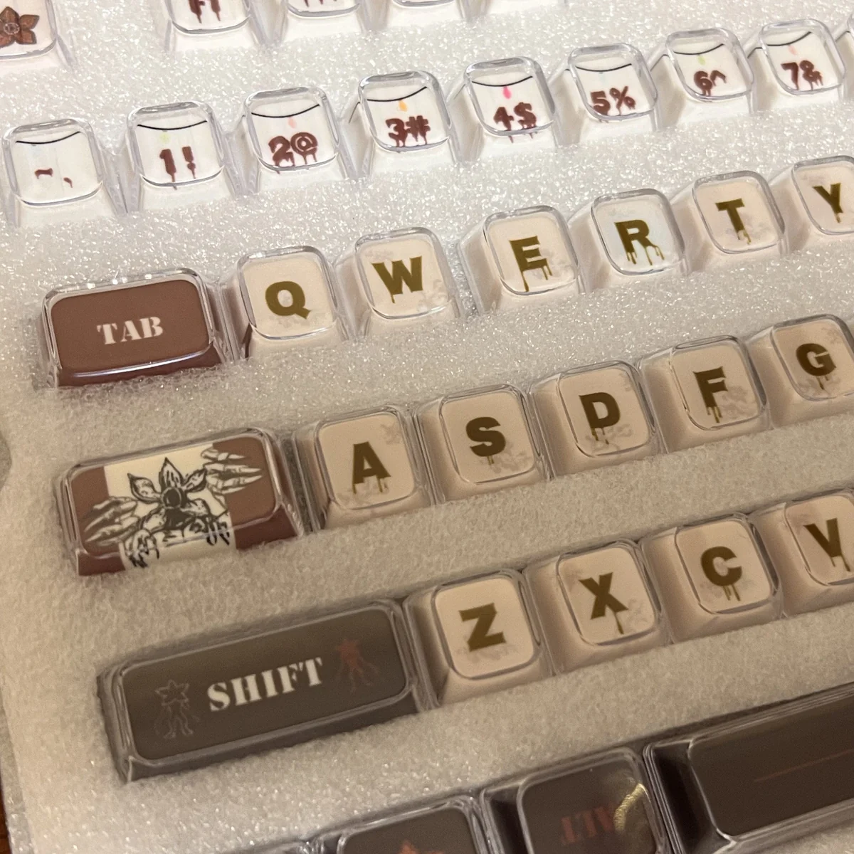 Explore multiple angles of Stranger Things Amber Pudding PBT keycaps, revealing their iconic translucent amber glow and retro 80s iconography.