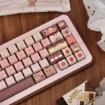 Dye-sublimated Strawberry Chocolate MOA PBT dessert keycaps in pastel pink and brown with strawberry cake and gingham motifs on a keyboard.