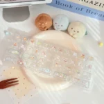 Adorable Sumikko Gurashi MOA translucent keycaps, showcasing their milky finish and soft rounded profile from a playful, unique angle.