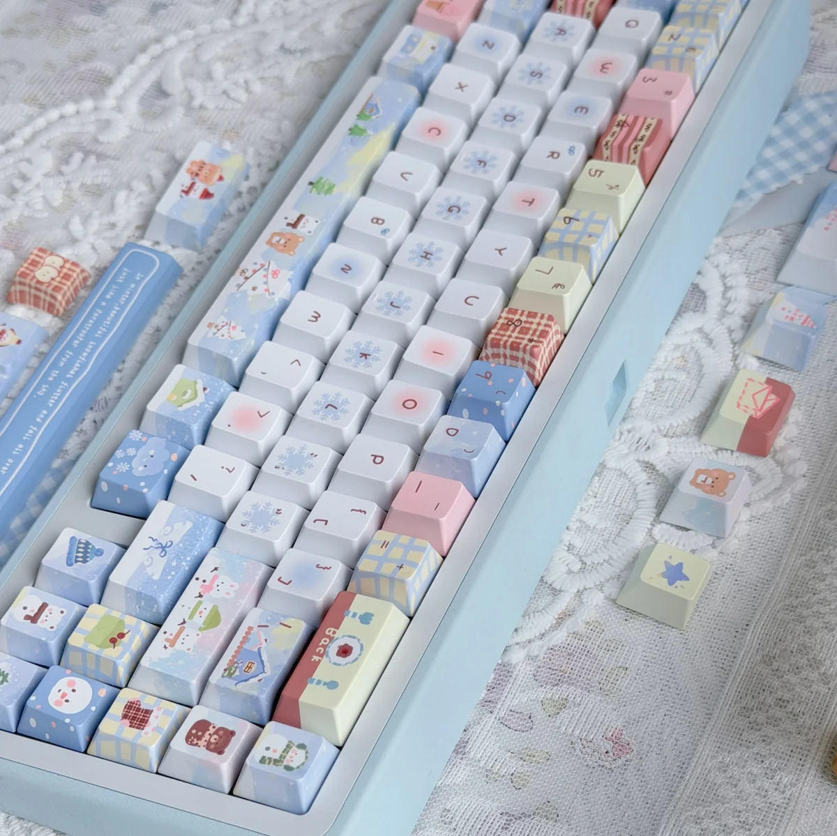 Close-up of a Cozy Winter Bear PBT Dye-sub Keycap set, highlighting playful bear designs and snowy forest details in soft, muted tones.