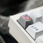 Close-up view of the Wuthering Waves Aemeath hand-carved titanium keycap, showcasing its intricate futuristic design and premium metal finish.