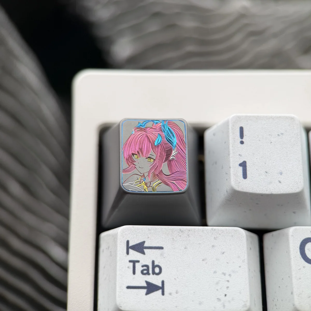 Close-up of a premium Wuthering Waves Aemeath hand-carved titanium keycap, showcasing its intricate futuristic design and exquisite metal finish.