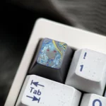 Close-up of the Wuthering Waves The Shorekeeper hand-carved titanium ESC keycap, showcasing intricate details and the metallic finish from a unique angle.