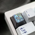 Close-up of the hand-carved Wuthering Waves The Shorekeeper titanium ESC keycap, highlighting its intricate, vibrant details and metallic luster from a unique angle.